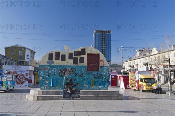 Beatles monument with graffiti and slogans on Tserendorjiin Gudamj Street in front of street food carts, capital Ulan Bator, Ulanbator, Ulaanbaatar, Mongolia, Asia