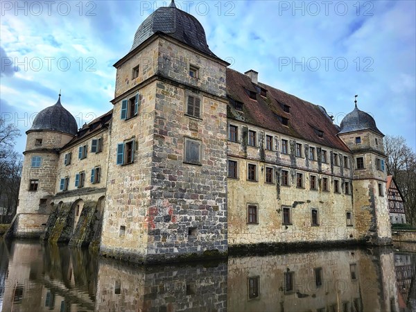 Mitwitz moated castle under a cloudy sky. Mitwitz, Kronach, Upper Franconia, Bavaria, Germany, Europe