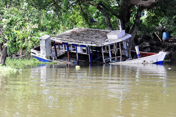 Granada, Nicaragua, Half-sunken boat at Lake Nicaragua surrounded by lush greenery, Central America, Central America