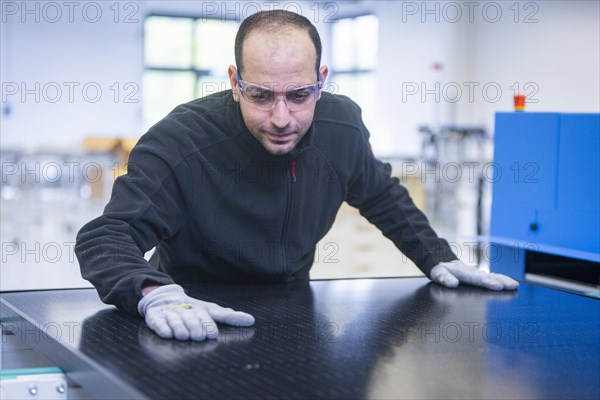 Sunmaxx PVT is a new innovative developer of photovoltaic thermal solar modules. The Fraunhofer ISE has confirmed an overall efficiency of 80% for the PX-1 premium module. The innovation is the combination of photovoltaics and solar thermal energy in one element. Employee Emad Sidhorn at a PVT module, Ottendorf-Okrilla, Saxony, Germany, Europe