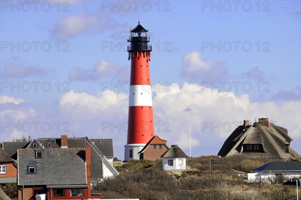 Lighthouse, Hoernum, Sylt, North Frisian Island, Schleswig Holstein, A striking red and white striped lighthouse stands behind a row of houses, Sylt, North Frisian Island, Schleswig Holstein, Germany, Europe