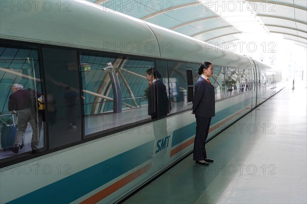 Shanghai Transrapid Maglev Shanghai Maglev Train Station Station, Shanghai, China, Asia, A uniformed person stands waiting on the platform next to a stationary train, Asia