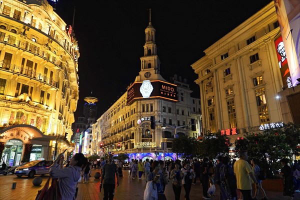 Evening stroll through Shanghai to the sights, Shanghai, Night-time street with brightly lit buildings and passers-by, Shanghai, People's Republic of China