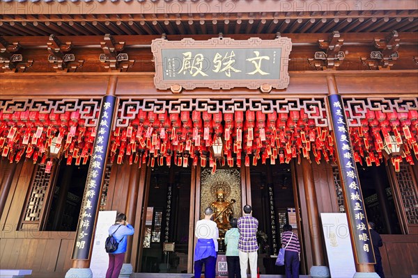 Jade Buddha Temple, Shanghai, Visitors pray in front of a traditional temple with red lanterns and a wooden structure, Shanghai, China, Asia