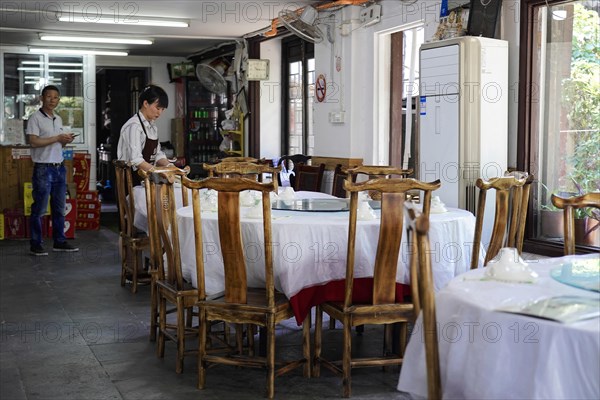 Excursion to Zhujiajiao Water Village, Shanghai, China, Asia, Empty restaurant with wooden tables and chairs and a visible employee, Asia