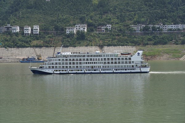 Cruise ship on the Yangtze River, A large white cruise ship is anchored in the river near green hills, Chongqing, Chongqing Province, China, Asia