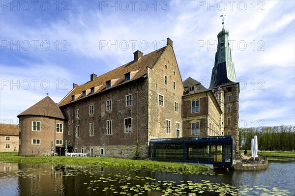 View over wide moat to historic moated castle from Renaissance Schloss Raesfeld, water lilies in the foreground, Freiheit Raesfeld, Muensterland, North Rhine-Westphalia, Germany, Europe