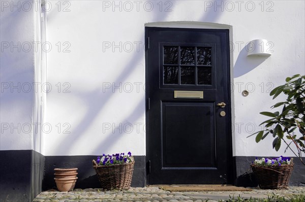 House entrance, Keitum, Sylt, North Frisian Island, Black front door of a house with side light, surrounded by flower baskets and soft shadows, Sylt, North Frisian Island, Schleswig Holstein, Germany, Europe