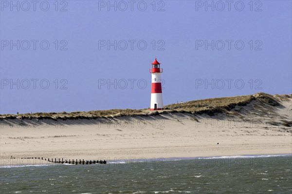 Lighthouse with blue sky at the elbow, North Sea, North Sea island, island, Sylt, red and white lighthouse on a sand dune under blue sky, Sylt, North Frisian island, Schleswig Holstein, Germany, Europe