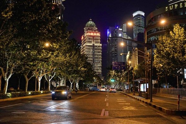 Shanghai by night, China, Asia, Illuminated night view of a city street with modern buildings and few cars, Shanghai, Asia