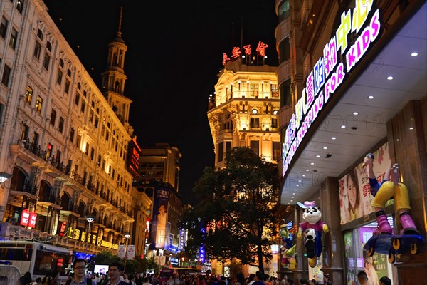 Evening stroll through Shanghai to the sights, Shanghai, Night view of the city with brightly lit billboards and passers-by on a busy shopping street, Shanghai, People's Republic of China