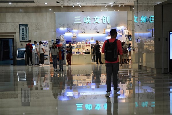 Chongqing, Chongqing Province, China, Asia, People in a shopping area with shiny floors and brightly lit advertising signs, Asia