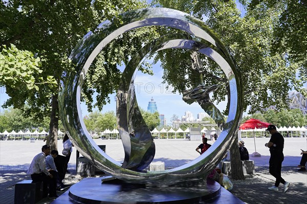 Beijing, China, Asia, Reflecting sculpture in public space, surrounded by trees and seated people, Asia