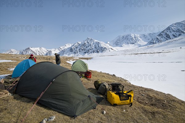 Tents in expedition camp in front of the mountain peaks in the snowy Tavan Bogd National Park, Mongolian Altai Mountains, Western Mongolia, Mongolia, Asia