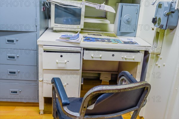 Interior of officer's cabin with desk chair computer and magazines inside battleship on display at Unification Park in Gangneung, South Korea, Asia