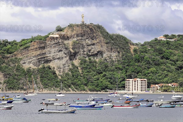 San Juan del Sur, Nicaragua, A statue of Jesus is enthroned on a wooded hill above a bay with boats, Central America, Central America