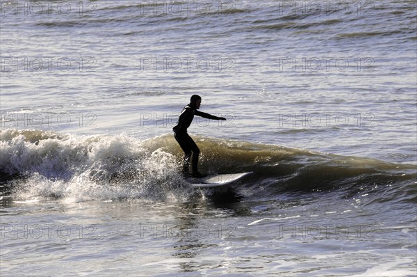 Westerland, Sylt, Schleswig-Holstein, Germany, Europe, Surfer riding a wave in the sea, surrounded by foam and spray, North Frisian Island, Schleswig Holstein, Europe