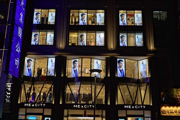 Shanghai by night, China, Asia, Night view of an illuminated shop with fashion presentation in the shop window, Shanghai, Asia