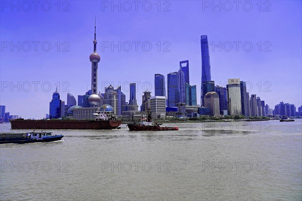 View from the Bund to the skyline on the Huangpu River with Oriental Pearl Tower, World Financial Centre, Shanghai Tower, Jin Mao Building in the Pudong district, Shanghai, China, Asia, Wide view over a river with a skyline of skyscrapers and passing ships, Asia