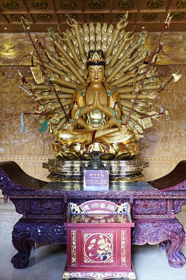 Chongqing, Chongqing Province, China, Asia, Golden Buddha with many arms, surrounded by religious symbols and ornaments, Asia