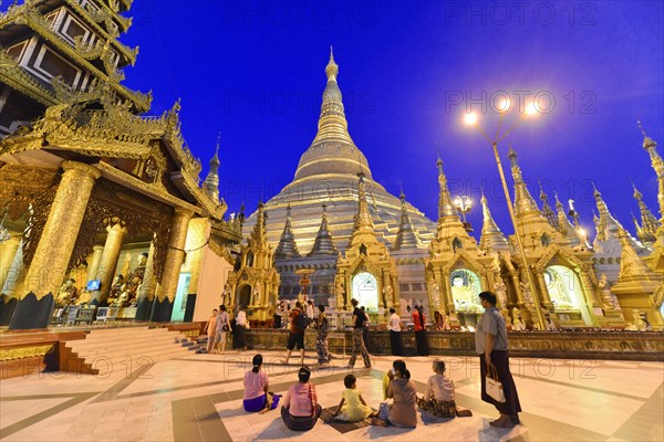 Shwedagon Pagoda, Yangon, Myanmar, Asia, Visitors at the pagoda in the evening light under a deep blue sky, the atmosphere is peaceful, Asia