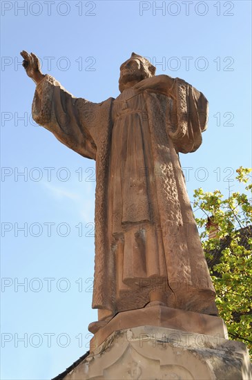 Kaysersberg, Alsace Wine Route, Alsace, Departement Haut-Rhin, France, Europe, Statue of a religious figure in front of a clear sky, raised hand pose, Europe