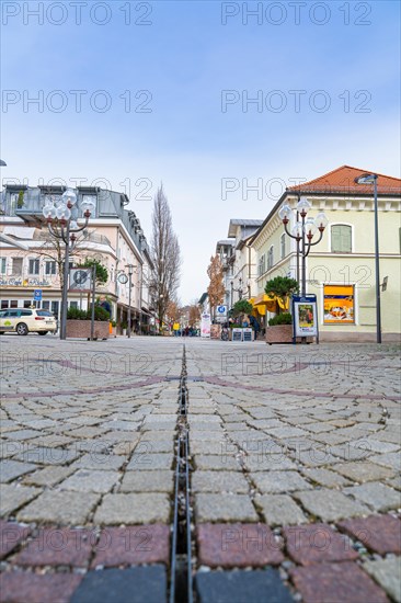 View along the cobbled town street with rows of shops and lanterns, Bad Reichenhall, Bavaria, Germany, Europe