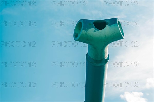 Closeup of muzzle brake on end barrel of tank gun with signs of wear and usage against a beautiful blue sky in Nonsan, South Korea, Asia