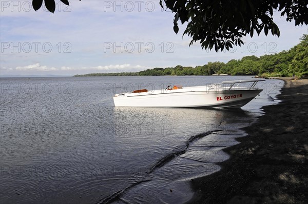 Ometepe Island, Nicaragua, White motorboat on calm shore with cloudy sky in the background, Central America, Central America
