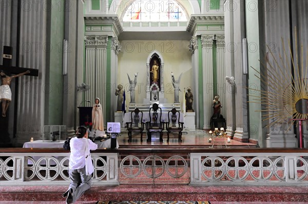 Church Iglesia de Guadalupe, built 1624 -1626, Granada, Nicaragua, woman praying in the church interior towards the altar with statues, Central America, Central America -, Central America