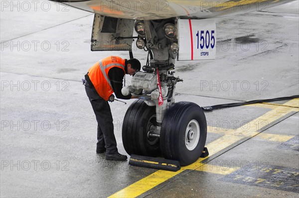 AUGUSTO C. SANDINO Airport, Managua, Nicaragua, An airport employee checks the landing gear of an aircraft at the gate, Central America, Central America