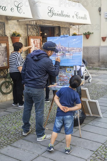 Artist with young spectator in Alghero old town, Sassari province, Sardinia, Italy, Mediterranean, Southern Europe, Europe