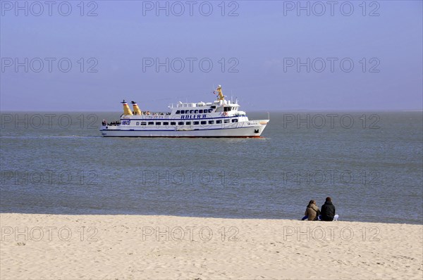 Sylt, North Frisian Island, Schleswig-Holstein, A ship is sailing on the sea, in the foreground a couple sitting on the beach, Sylt, North Frisian Island, Schleswig-Holstein, Germany, Europe