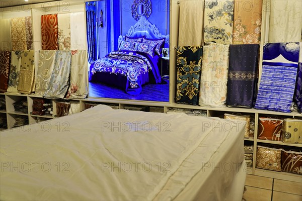 Silk factory Shanghai, A bed surrounded by patterns and fabric panels in a textile shop, Shanghai, China, Asia