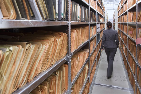 An employee of the Federal Commissioner for the Records of the State Security Service of the former German Democratic Republic, BStU, walks past cabinets with Stasi index cards. Files and documents of the Ministry for State Security of the GDR are stored in the Stasi Records Office, 17.01.2015., Berlin, Berlin, Germany, Europe