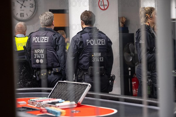 Police officers look at evidence on a casino table during an investigation, The Cologne police led a raid against illegal gambling on Friday evening. Around 200 investigators from the police, customs, tax investigation, the public order office, the tax and revenue office, the immigration office and the gas licence office are on the streets of Cologne on Friday evening. They search 25 properties where there are indications that illegal gambling is taking place. And they make a find