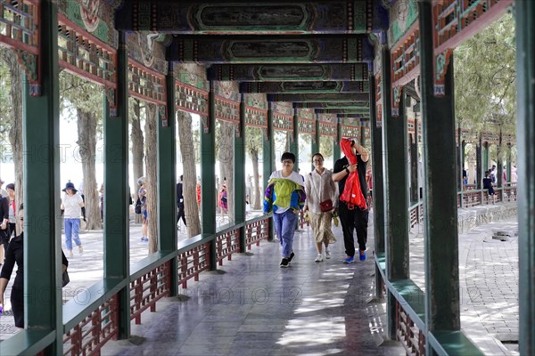 New Summer Palace, Beijing, China, Asia, Tourists walk through a historic corridor with elaborate wood carvings, Beijing, Asia