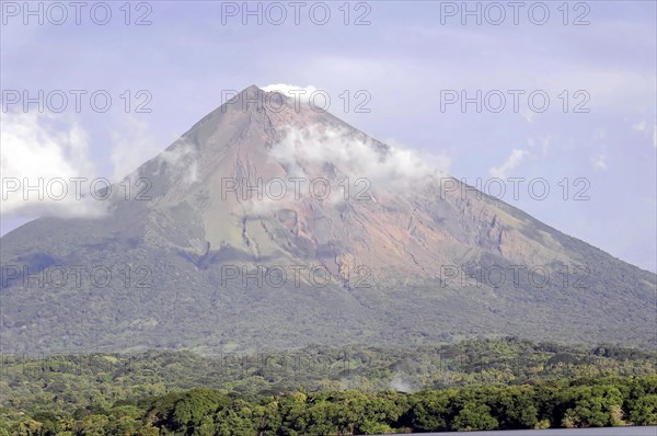 Lake Nicaragua, in the background the island of Ometepe, detailed view of an active volcano with smoke clouds around the top and dense vegetation at the base, Nicaragua, Central America, Central America