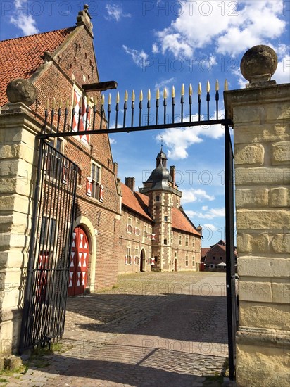 View through the north gate onto the castle courtyard with cobblestones on the outer bailey of the moated castle Schloss Raesfeld, in the background Sterndeuterturm, excursion destination in North Rhine-Westphalia, Freiheit Raesfeld, Muensterland, North Rhine-Westphalia, Germany, Europe