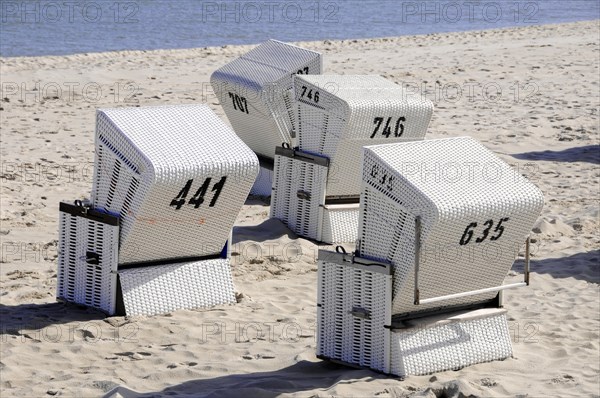 On the beach, Hoernum, Sylt, North Frisian Island, White beach chairs with numbers on a sandy beach in sunny weather, Sylt, North Frisian Island, Schleswig-Holstein, Germany, Europe