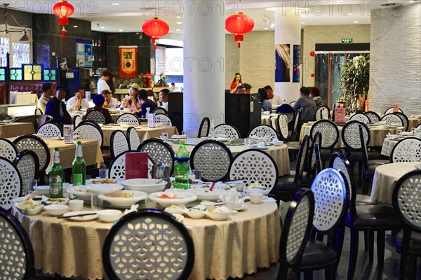 Dinner in a posh restaurant in Shanghai, China, Asia, Guests sitting at round tables in a Chinese restaurant with traditional decoration, Shanghai, Asia