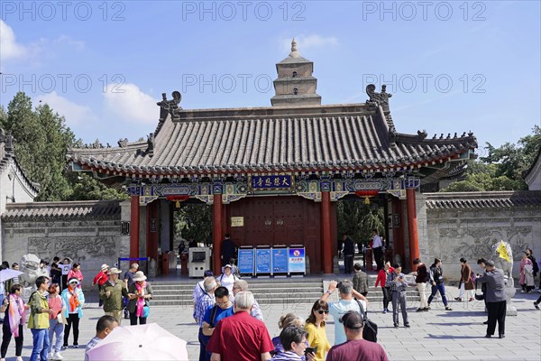 Chongqing, Chongqing Province, China, Asia, Entrance gate to a Chinese temple with people and information signs, Asia