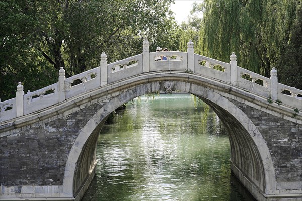 New Summer Palace, Beijing, Beijing, China, Asia, Traditional Chinese arch bridge over a lake with trees in the background, Asia
