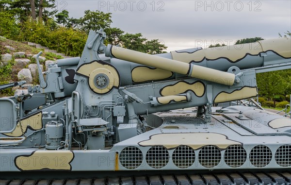 Closeup of military tank with camouflage paint on display in public park near Nonsan, South Korea on overcast day