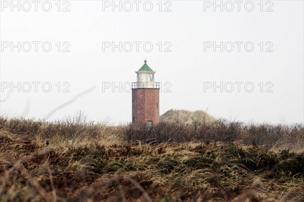 Lighthouse of Kampen, Small brick lighthouse stands between dunes under a cloudy sky, Sylt, North Frisian Island, Schleswig Holstein, Germany, Europe