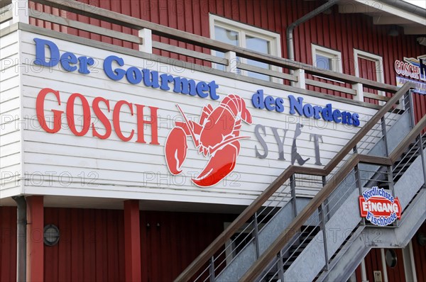 Logo Gosch Sylt on the back of the restaurant, harbour of List, North Sea island of Sylt, North Frisia, advertising for 'Der Gourmet des Nordens' on a red house wall, Sylt, North Frisian island, Schleswig Holstein, Germany, Europe