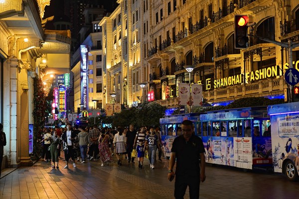 Evening stroll through Shanghai to the sights, Shanghai, Crowd on a night-time shopping street with neon signs, Shanghai, People's Republic of China