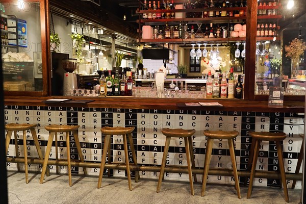 Evening stroll through Shanghai to the sights, Shanghai, Empty bar with chairs and various bottles, in the background a wall with typography, Shanghai, People's Republic of China