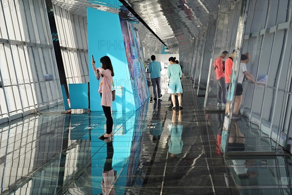 Viewing terrace, The Bottle Opener at 492 metres, visitors in front of a blue exhibition wall on a reflective viewing platform, Shanghai, China, Asia