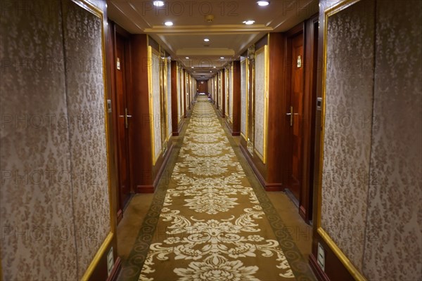 Cruise ship on the Yangtze River, Yichang, Hubei Province, China, Asia, View through a long, elegant hotel corridor with patterned carpet and wooden doors, Shanghai, Asia